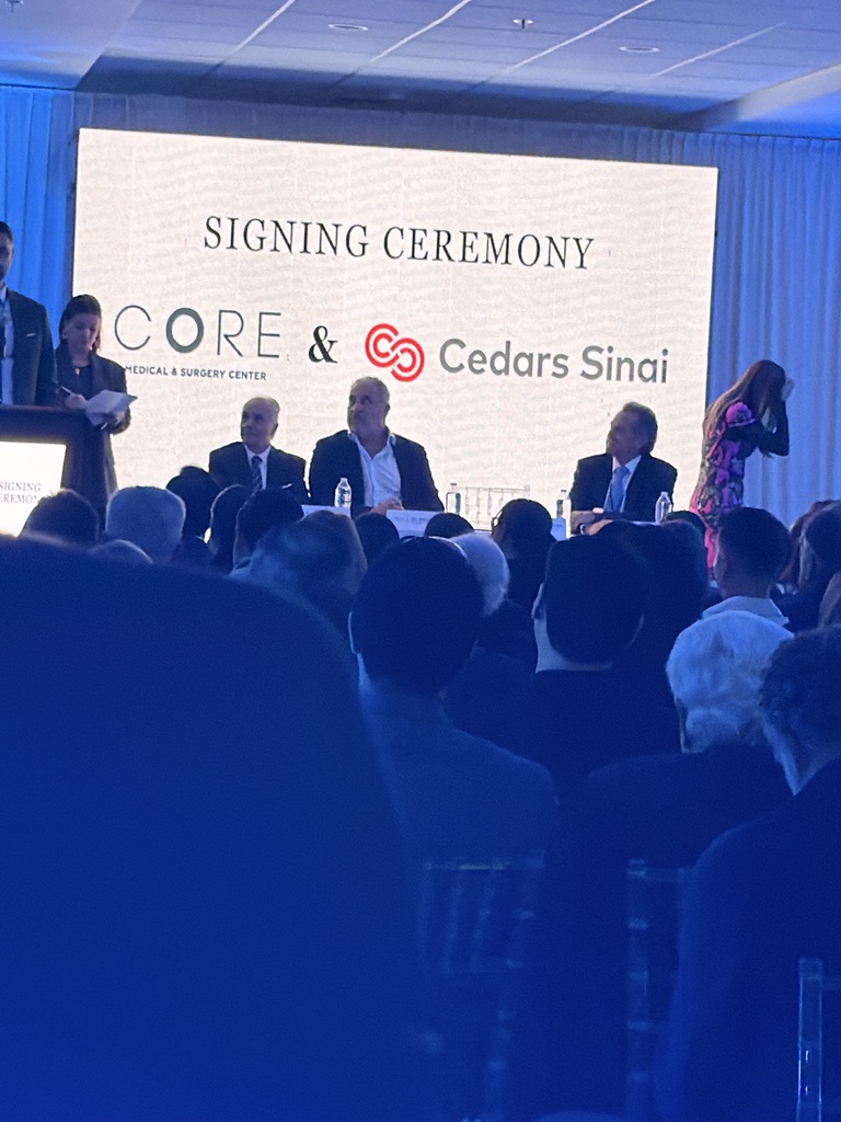 Andrew Hillman. Signing ceremony of CORE hospital with Cedars Sinai. Backdrop text: SIGNING CEREMONY, CORE Medical & Surgery Center & Cedars Sinai.