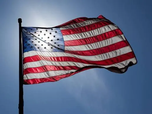 Backlit American flag against a blue sky on Andrew Hillman's site